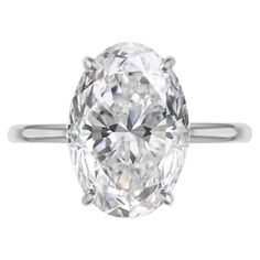 an oval cut diamond ring on a white background