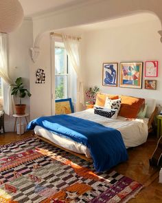 a bed sitting in a bedroom on top of a wooden floor next to a window