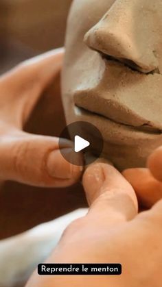 someone is making clay on their face with one hand and the other holding something in front of them