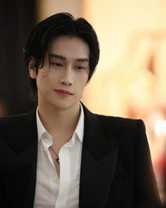 the young man is wearing a black suit and white shirt