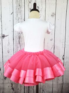 Pink Tulle Tutu Skirt Make her twirl with delight in our Pink Tulle Tutu Skirt. Our premium tulle is soft against the skin and won't snag, scratch, or irritate. Double-faced satin ribbon adds a sweet, elegant touch, while our sizing chart ensures a perfect fit. Spark her imagination and unleash her inner princess. Lead time to sew and ship is 3 business days Spring Stretch Tulle Skirt, Spring Tulle Skirt With Stretch, Stretch Ruffle Petticoat Skirt, Spring Tutu Dance Dress, Spring Dance Tutu Dress With Stretch, Stretch Tulle Tutu Dress With Ruffles, Pink Tulle Full Skirt Bottoms, Pink Tulle Full Skirt, Spring Balletcore Stretch Skirt