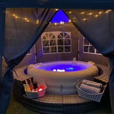 an outdoor hot tub with lights on the outside