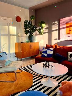 a living room filled with lots of furniture and decor on top of a black and white rug