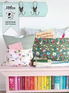 the bookshelf is filled with many colorful pillows and pillow cases on top of it