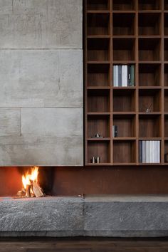 a fire place in the middle of a room with bookshelves