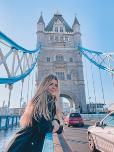 a woman standing on the side of a bridge