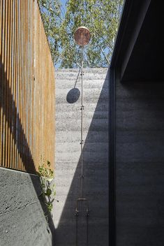 an outdoor shower in the middle of a concrete wall and wooden slatted walls