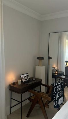 a bedroom with a desk and mirror in it