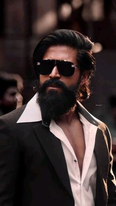 a man with a beard wearing sunglasses and a suit