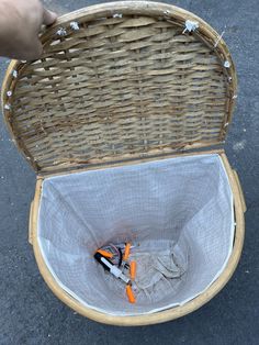 a basket with scissors in it sitting on the ground