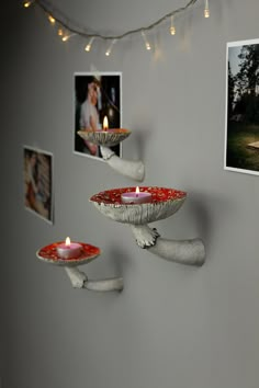 candles are lit on the wall in front of pictures