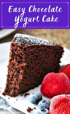 a slice of chocolate yogurt cake on a plate with strawberries and blueberries