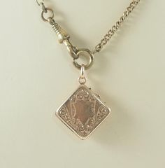 A charming antique Victorian lozenge shaped locket or watch chain fob in gold filled, rolled gold, in a rose gold tone.  The  locket is set to one side with a mother of pearl panel. To the other side is gold filled with a shield shaped cartouche for initials with a scroll surround. Opening to reveal space for one square photographs, no frame or glass covering. With an oval bail. The chain is for display only. Germany, 1890-900. 4.9g The mother of pearl panel 1.7cm square when measured as a lozen Pearl Locket, Wedding Gift Baskets, Victorian Gold, First Photograph, Watch Chain, Locket Necklace, Antique Victorian, Locket, Or Rose