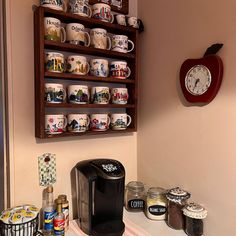 a coffee maker sitting on top of a counter next to some cups and saucers