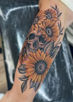 a person with a sunflower tattoo on their arm and hand is holding a flower