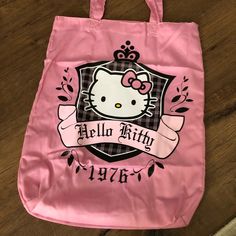 a pink hello kitty shopping bag sitting on top of a wooden floor