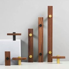 three pieces of wood and metal on a white counter top next to a wall mounted device