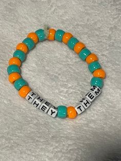 hi there! welcome back to loom mountain! ☮️ this listing is for a kandi or pony bead bracelet on a thick stretch cord, with "they/them" in the middle. the surrounding beads are teal and orange. thanks again for stopping by! They Them, Pony Bead Bracelets, They Them Pronouns, Teal And Orange, Pony Beads, Bead Bracelet, Arm Band, Welcome Back, Loom