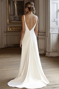 A woman in a white, backless wedding gown with a long, flowing train stands in an elegantly decorated room with wooden floors and ornate wall moldings. Her hair is styled in an updo. Long Plain Wedding Dress, Minimalist Wedding Gown Simple, Voile Wedding Dress, Plain Bride Dress, Simple Wedding Dress Silk Satin, Simple Wedding Dress Long Train, Elegant Wedding Dress Low Back, Caroline Castigliano Wedding Dress, Bride Dress Simple Elegant