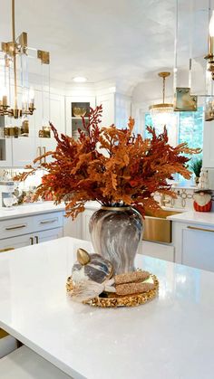 a vase filled with flowers on top of a white counter