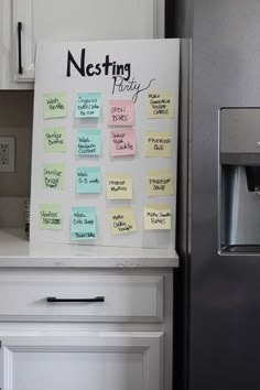 a refrigerator freezer sitting next to a white wall with post it notes on it