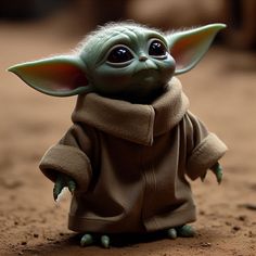 a baby yoda doll is posed on the ground