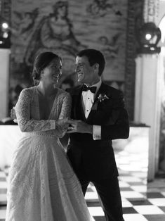 a man in a tuxedo and a woman in a wedding dress dance together