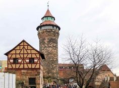 a tall tower with a clock on it's side next to a crowd of people