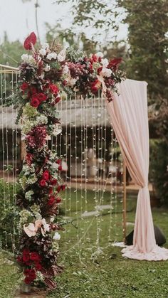 a wedding arch decorated with red and white flowers