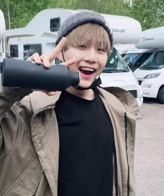 a young boy is smiling while holding his hand up to the camera