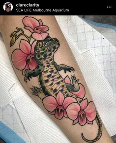 a lizard and flowers tattoo on the arm