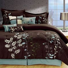 a bed with brown and blue comforters in a room