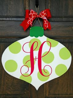 a christmas ornament hanging on a door with the letter f painted on it