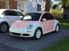 two cars parked next to each other in front of a white and pink house on the street