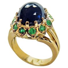 This dazzling 18K yellow gold sapphire emerald ring is centered with a cabochon cut blue Burmese Sapphire, that weighs 7.75 carats. Accenting this beautiful blue sapphire are twelve round green Colombian emeralds weighing 1.25 carat. Total Ring Weight: 11 grams. The face of the ring measures 17.42mm X 16.20mm, rising 12.00mm above the finger. Currently a US size 7.75 and easily adjustable. Sapphire Emerald Ring, Dome Rings, White Gold Sapphire Ring, Art Deco Emerald, Emerald Ring Vintage, Gold Sapphire Ring, White Gold Sapphire, Sapphire Diamond Ring, Wedding Rings Vintage