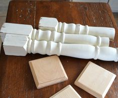 several pieces of wood sitting on top of a wooden table next to two square blocks