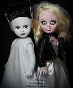 two dolls dressed in white and black are standing next to each other with green eyes