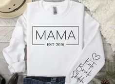 The Mama in your life is sure to love this personalized Mama EST sweatshirt. It makes a great gift or a New Mom announcement. Sweatshirts -Ideal for any situation, a unisex heavy blend crewneck sweatshirt is pure comfort. These garments are made from polyester and cotton. This combination helps designs come out looking fresh and beautiful. The collar is ribbed knit, so it retains its shape even after washing. There are no itchy side seams on these sweaters. Our items are made just for you!  HOW TO ORDER -Select the garment SIZE & COLOR -Enter Personalization -Select the quantity -Click Add to Cart **For multiple items go back to the listing and repeat the steps To keep the print looking fresh and trendy, wash in cold water, dry on low heat, and always turn inside out before washing.  Color Father's Day White Sweatshirt Gift, Custom Text White Tops For Mother's Day, Personalized Long Sleeve Tops With Custom Text, Custom Print Crew Neck Top For Personalized Gift, White Custom Text Tops For Mother's Day, Personalized White Top With Name Print, Personalized White Sweatshirt For Gift, Family Matching Custom Text White Sweatshirt, Family Matching White Sweatshirt With Custom Text