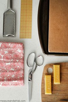 the cutting board is next to some scissors and cheese