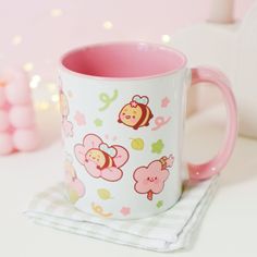 a pink and white coffee mug sitting on top of a table