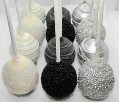 there are many different types of candies on the white tablecloth with black and silver decorations