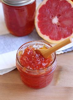 grapefruit jam in a jar with a wooden spoon next to it on a table