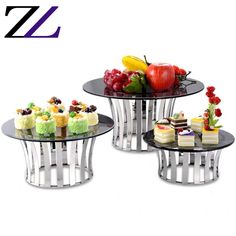 three tiered glass table with fruit and cake on it's sides, each serving tray