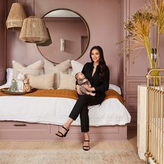 a woman sitting on a bed holding a baby