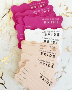 pink and white paper cutouts with gold foiling on marble countertop for bride's advice cards