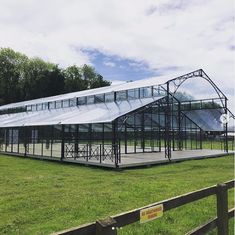 a large metal structure sitting on top of a lush green field