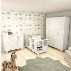 a baby's room with white furniture and green wallpaper