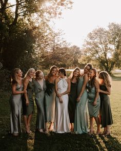 a group of women standing next to each other on top of a lush green field