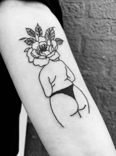 a black and white photo of a woman's arm with a flower on it