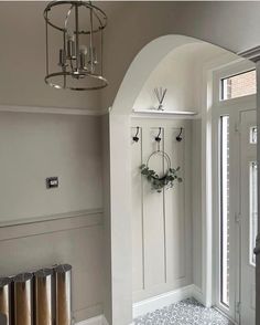 a white room with an arched doorway and two wreaths hanging on the wall next to it